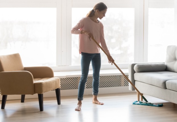 Young woman cleaning laminate floor | Specialty Flooring